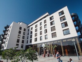 Un hotel moderno con varios pisos, balcones y fachada de vidrio.