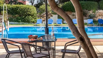 Una piscina al aire libre de temporada, sombrillas