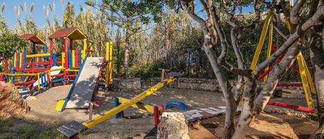 A playground with various play structures including a slide and swings.