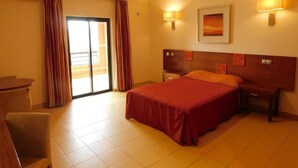A hotel room with a bed, bedside tables, a desk, and a chair. - Praia Sol (Vilamoura)