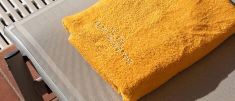 Una toalla amarilla con el texto "HOTEL" sobre una silla.