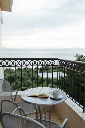 A balcony with a round table and two chairs, a book, and a cup. - Akti Taygetos Conference Resort (Kalamata)