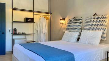 Une chambre à coucher comprenant un lit, une armoire, une étagère avec une bouilloire et une lampe fixée au mur.