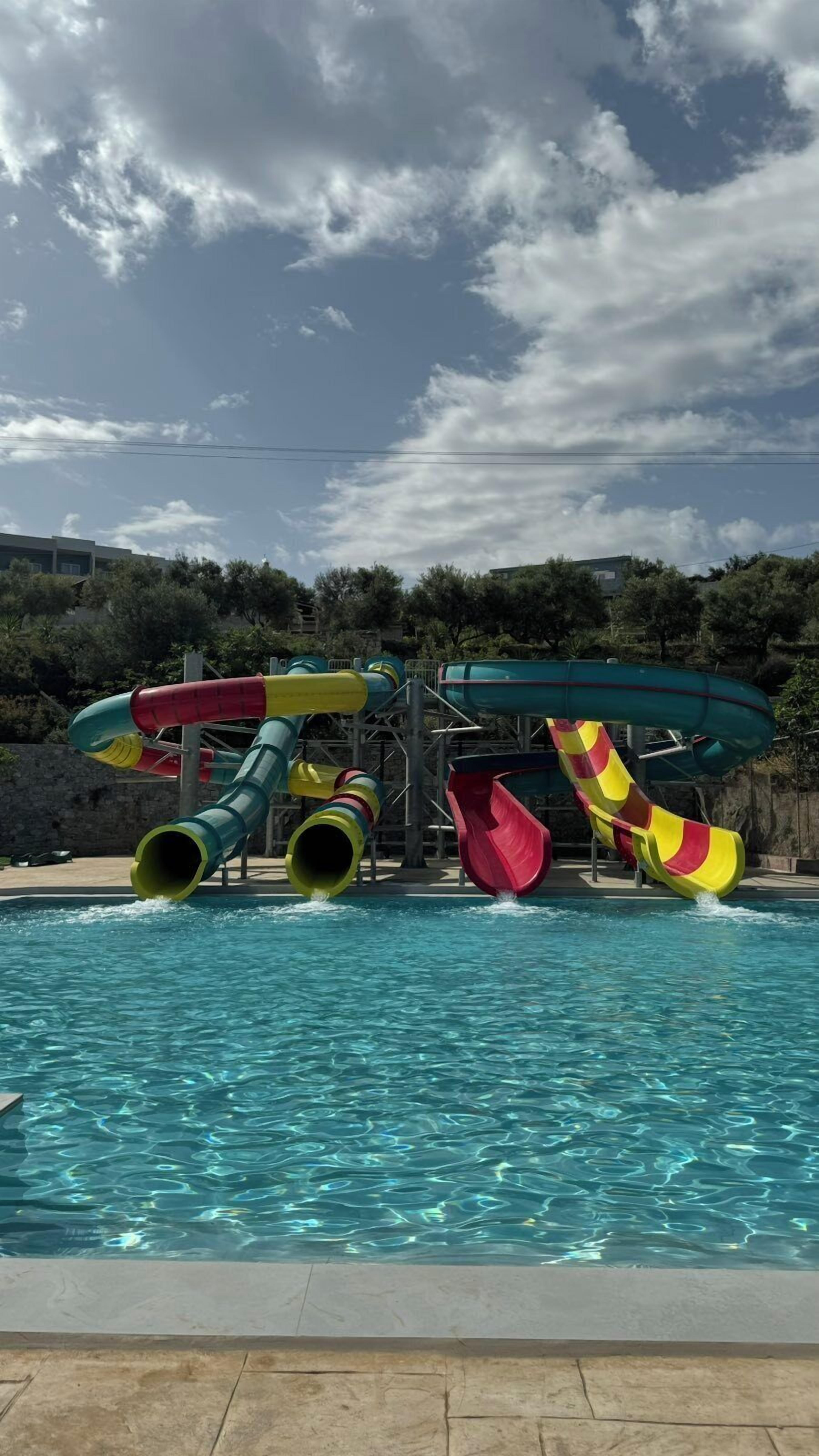 Parque acuático con toboganes sobre una piscina.
