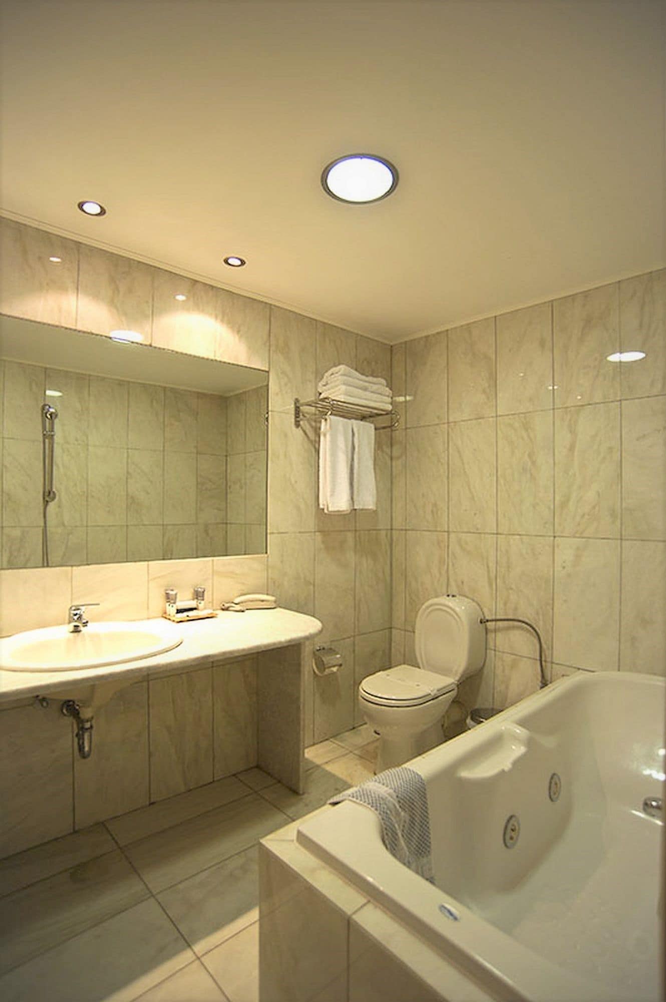 Une salle de bain moderne équipée d’un lavabo, de toilettes et d’une baignoire.