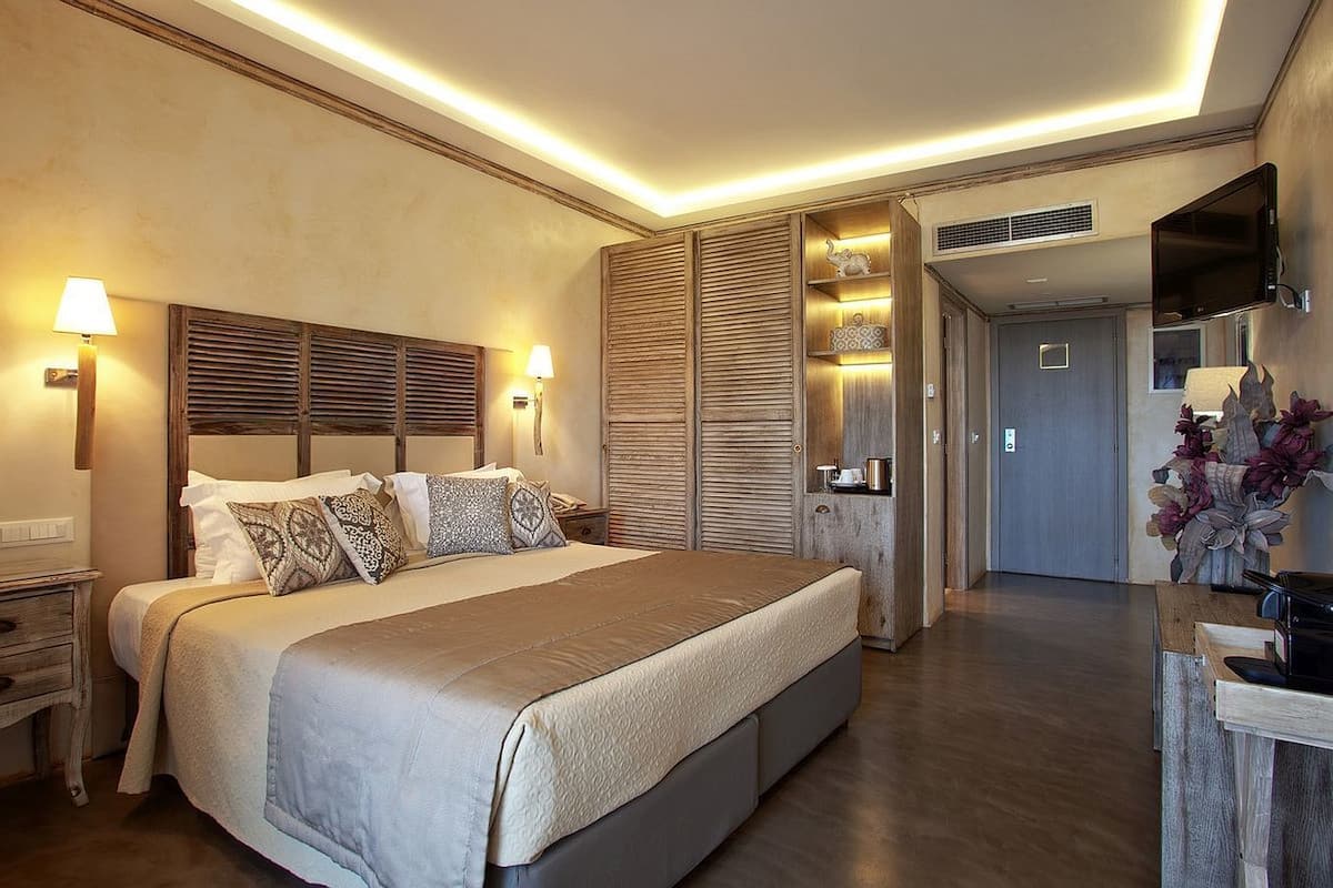 A modern bedroom with a large bed, wooden headboard, and built-in wardrobe.