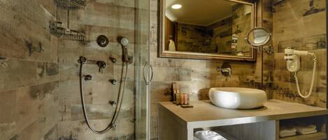 A bathroom with a wooden wall design, a large mirror, a sink, and a shower area.