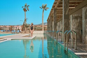 An infinity pool, open 10:00 AM to 6:00 PM, pool umbrellas