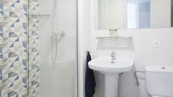 A bathroom with a shower, sink, and toilet.