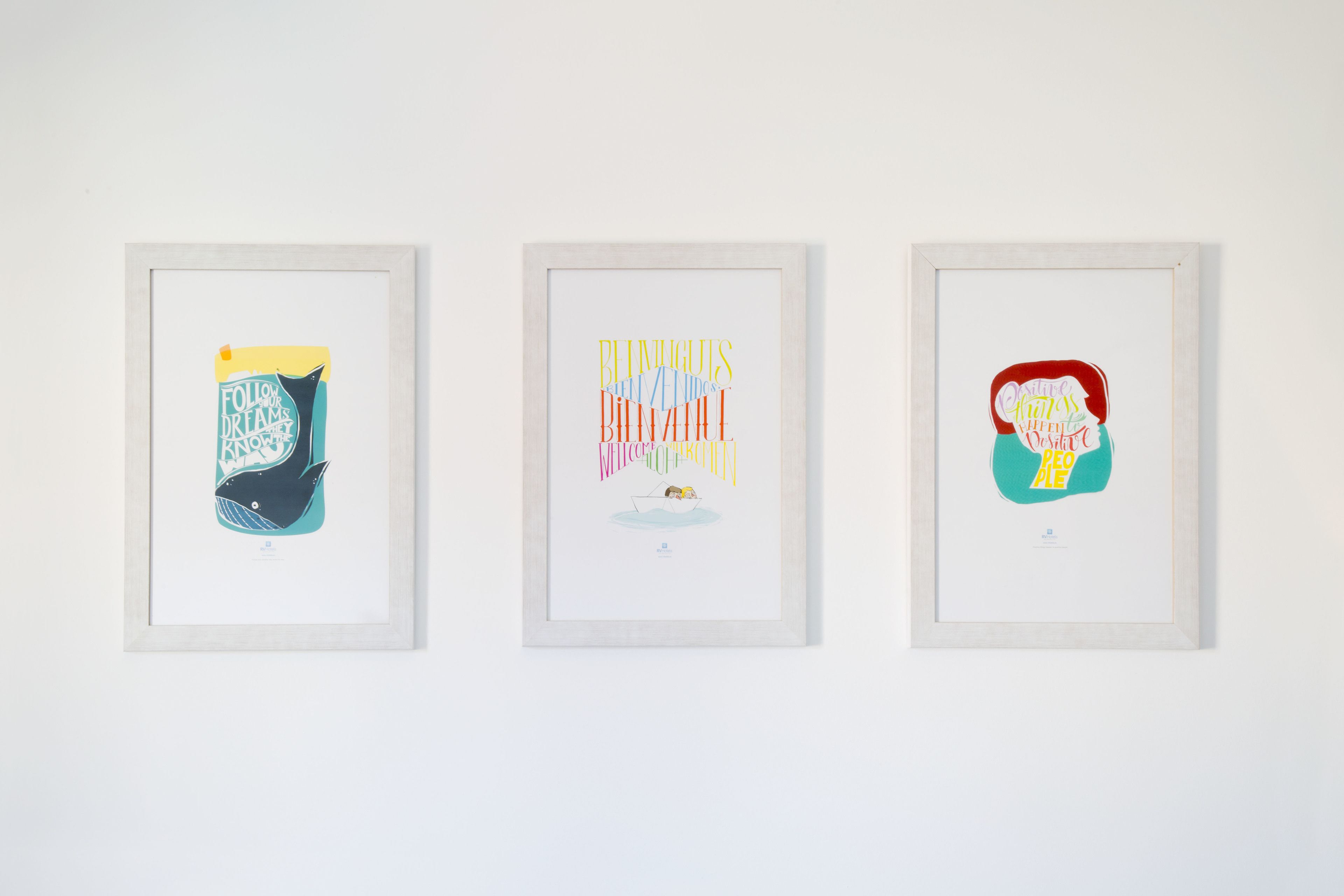 Tres obras de arte enmarcadas en una pared.