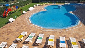 A swimming pool with a tiled deck and lounge chairs. - RVApartaments Estartit Confort (Torroella de Montgrí)