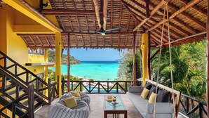 A covered outdoor seating area with a view of the ocean, a wooden staircase, and a thatched roof. - SAii Phi Phi Island Village (Ko Phi Phi)