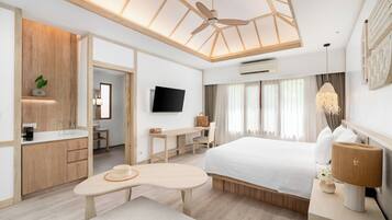 Una habitación de hotel moderna con techo de madera, una cama, un escritorio, un televisor y un baño con armarios de madera.