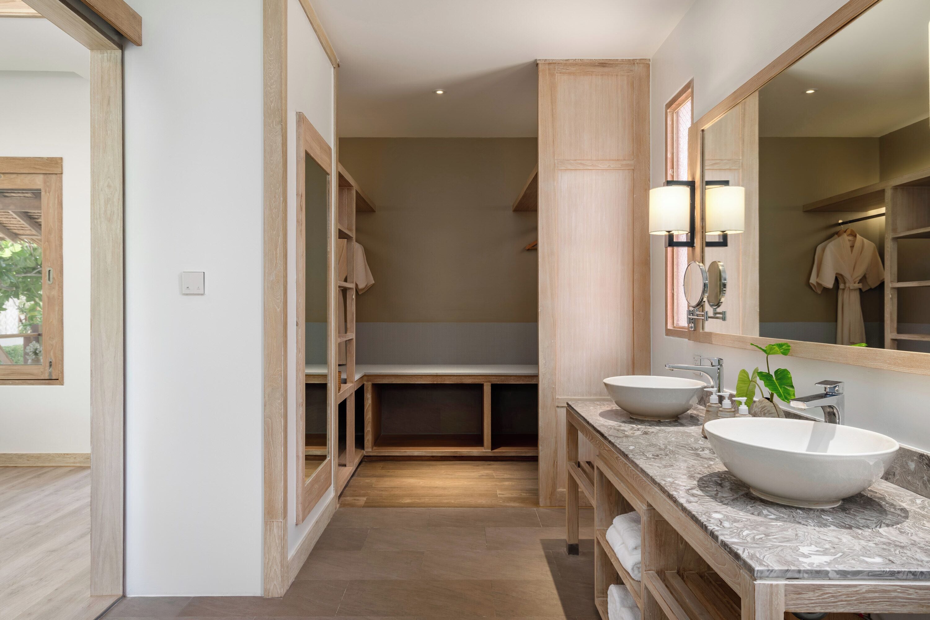 Une salle de bain moderne avec deux grands lavabos, un miroir et des meubles en bois.