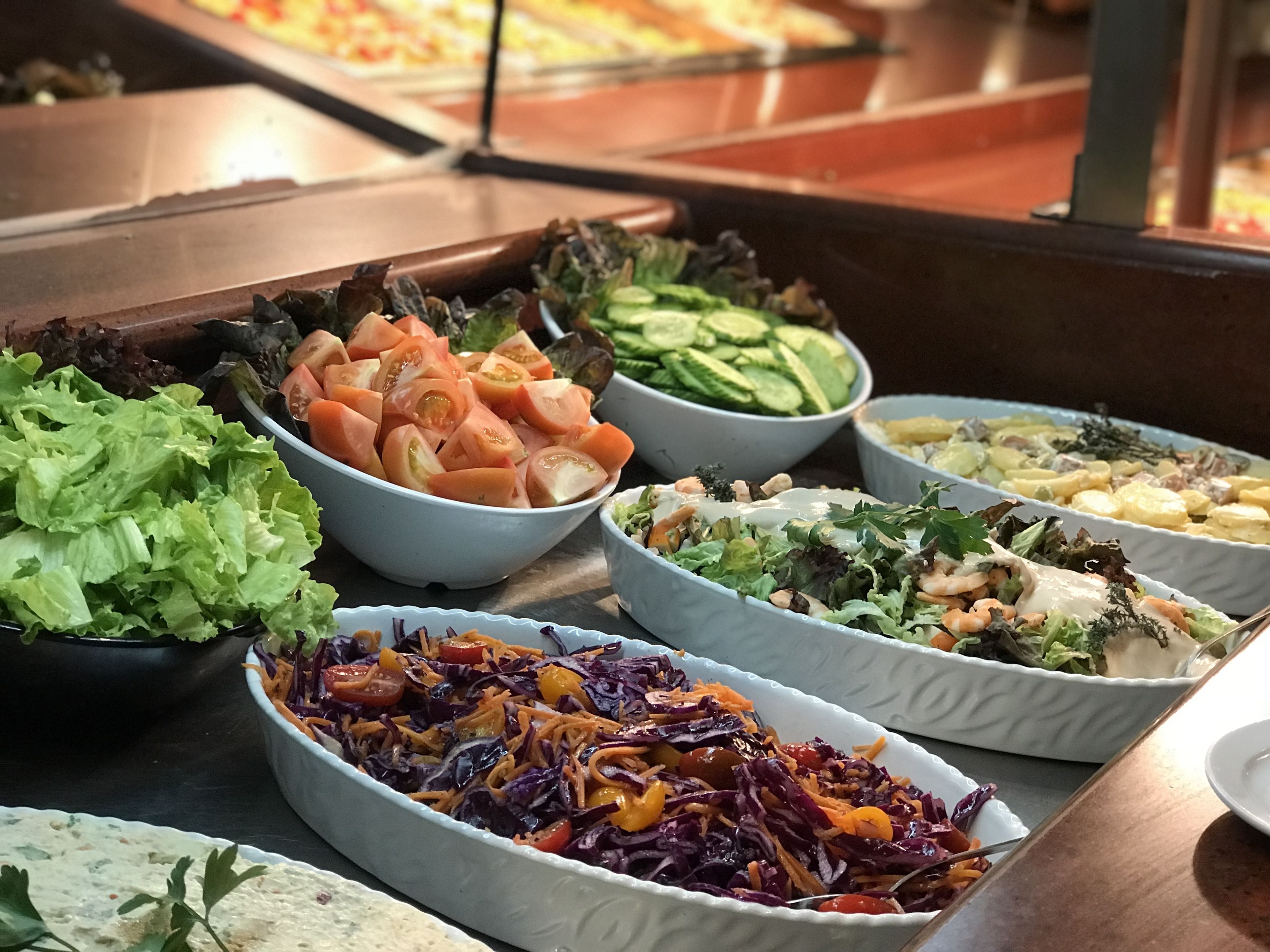 Een buffet met verschillende salades en gerechten.
