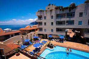 Un hôtel doté d’une piscine, d’un espace extérieur aménagé et offrant une vue sur la mer.
