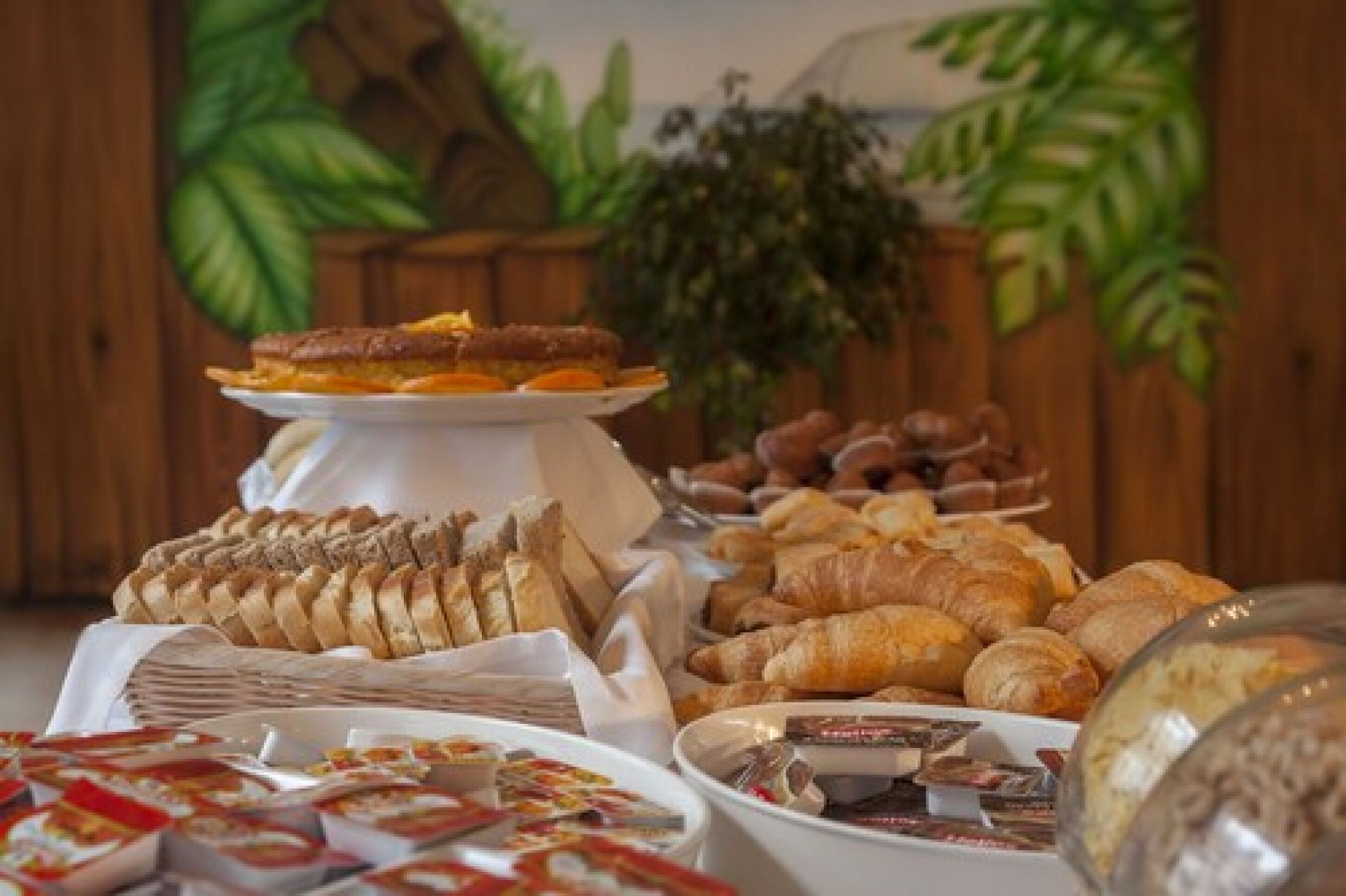 Un buffet con diversi pani, dolci e dessert.