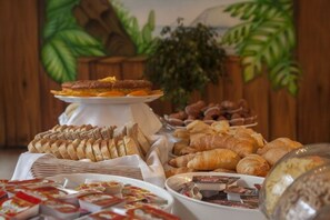 Un buffet proposant une variété de pains, de viennoiseries et de desserts.