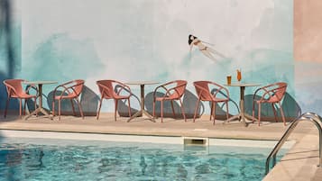 Una piscina techada, una piscina al aire libre, sombrillas