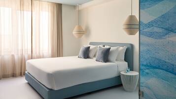 Een moderne slaapkamer met een bed, gordijnen, een nachtkastje en een muur met een geometrisch patroon.