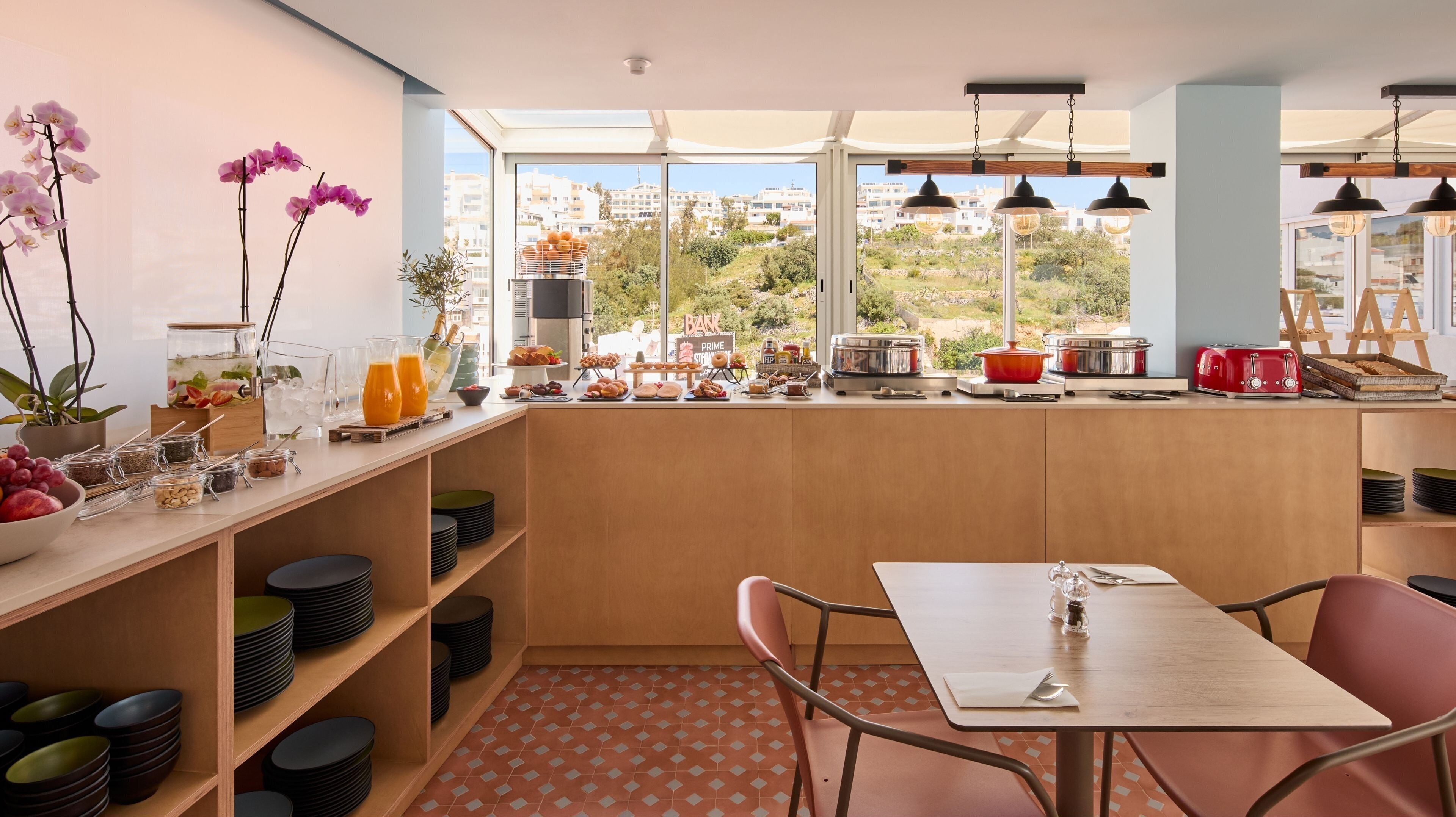Een moderne keuken met een ontbijtbalk, grote ramen en stadszicht.