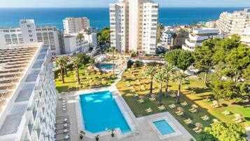 Alberca al aire libre, sombrillas en la alberca y camastros