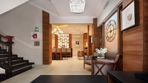 A hotel lobby with a staircase, a reception desk, and a dining area. - BON Hotel Abuja (Abuja)