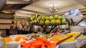A buffet with various fruits and vegetables, including bananas, apples, and carrots. - BON Hotel Abuja (Abuja)