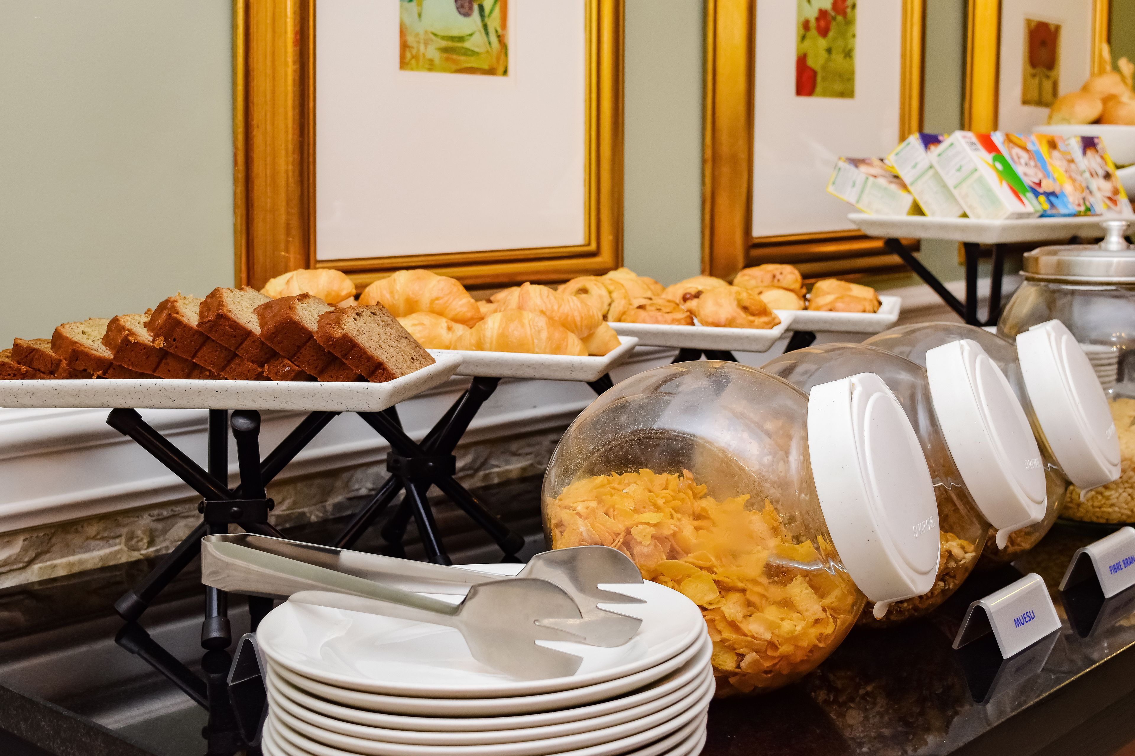 A buffet with bread, croissants, and various breakfast items.