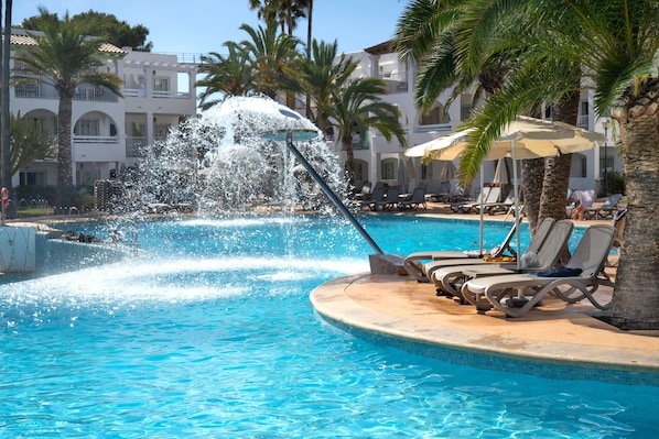 Een buitenzwembad, parasols voor strand/zwembad