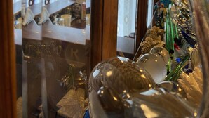 A room with wooden paneling and a glass partition. There are various items on the partition, including a lamp, a small statue, and some decorative objects. - Dream (Mestre)