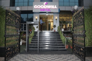Der Eingang zum Goodwill Hotel mit einer Treppe, die zum Eingang führt, flankiert von verzierten schwarzen Toren.