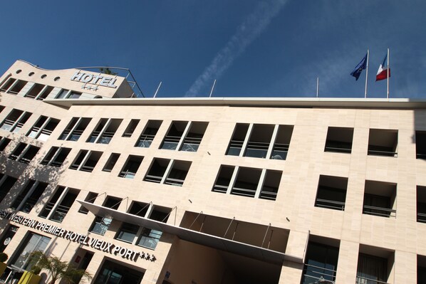 Un edificio de hotel con un letrero que dice "HOTEL" y "HOTEL WESTERN PREMIER VIEUX PORT".