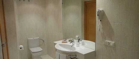 Un baño con inodoro, lavabo y espejo.