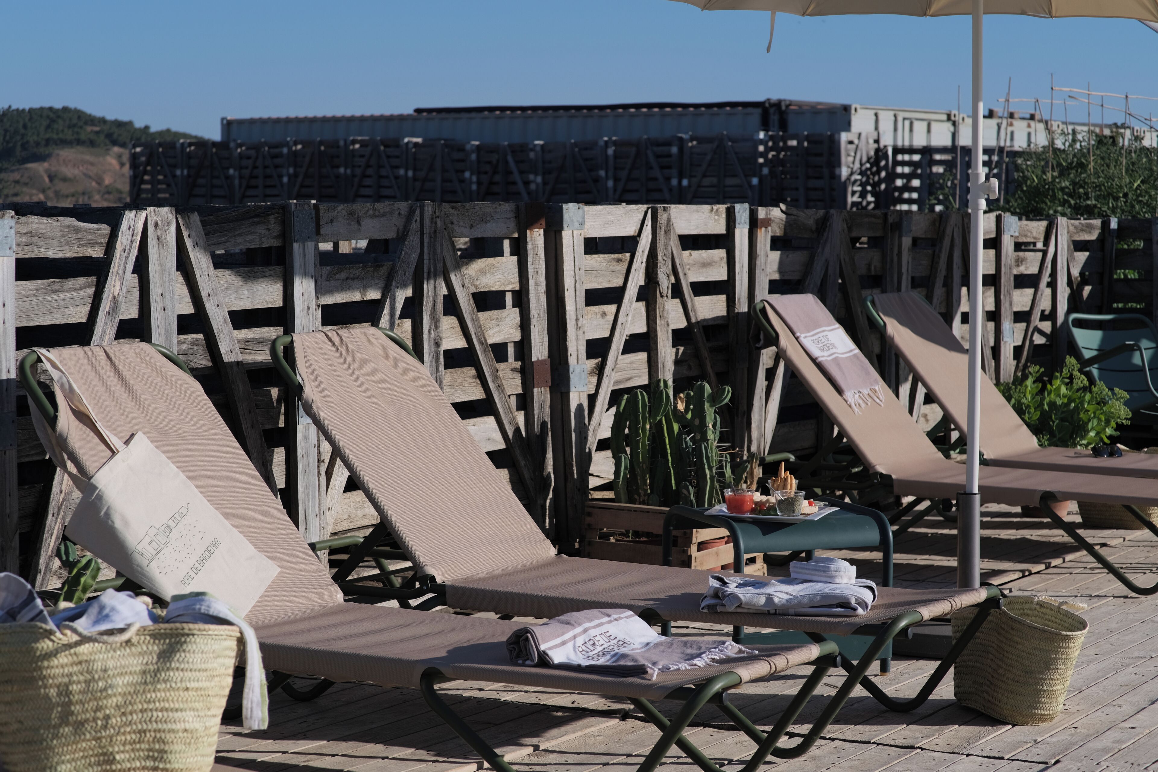 Een terras met lounge stoelen, een tafel en een mand.