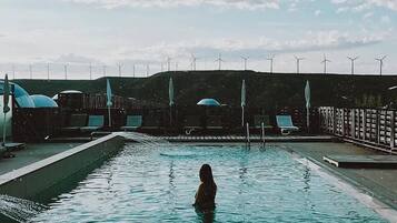 Relax by the serene pool surrounded by modern architecture and renewable energy sources.