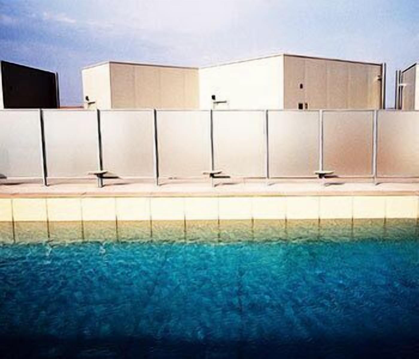 A modern building with a pool in front.