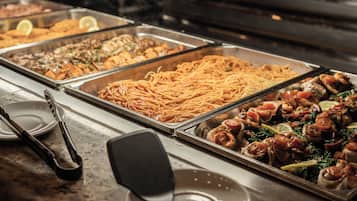 A buffet with various dishes including pasta, seafood, and salads.