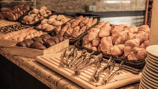 Mostrador de panadería con diversos productos horneados y utensilios de servicio.