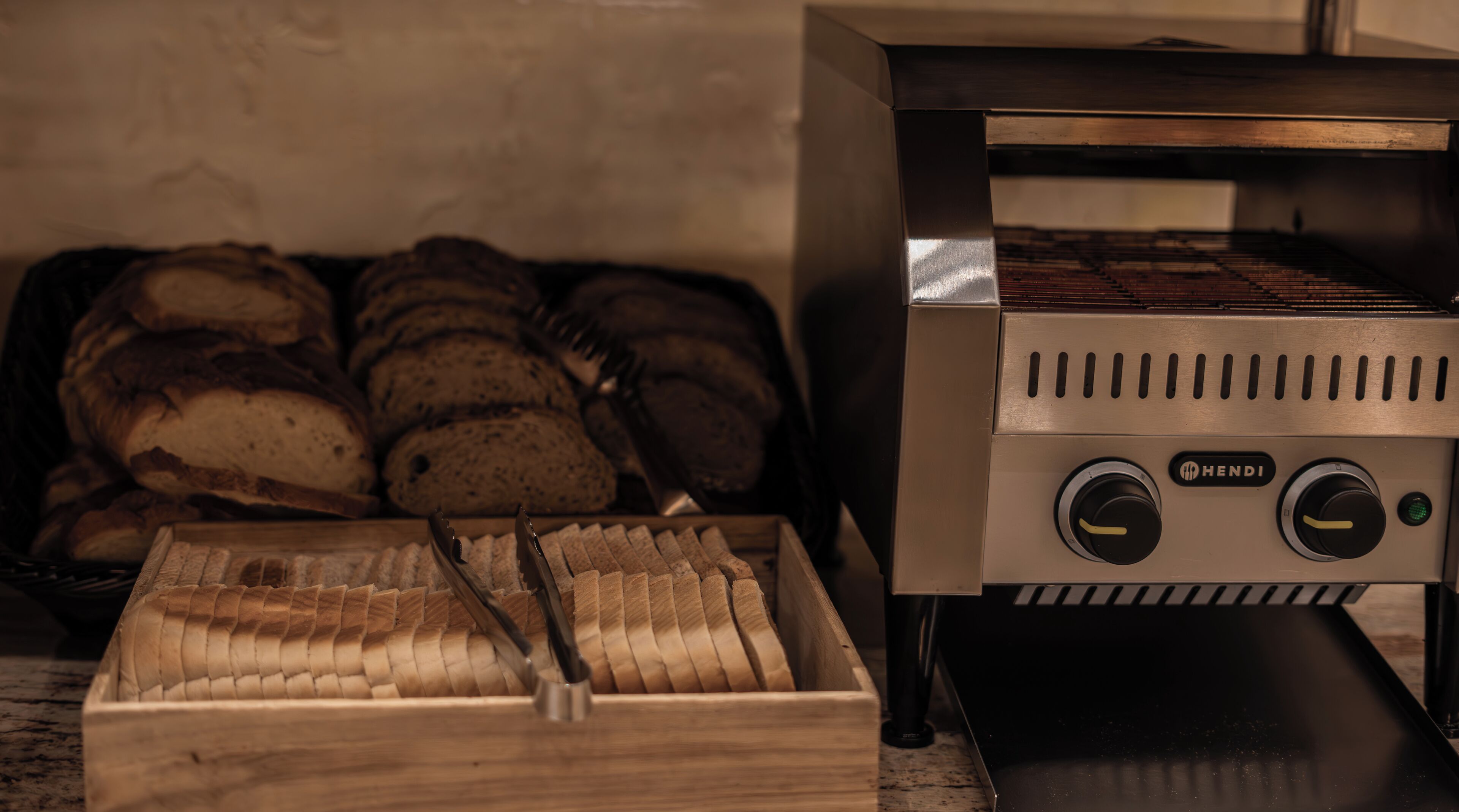 A bread display with a toaster oven and a wooden bread box.