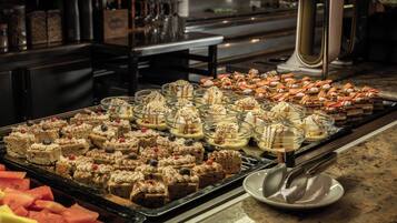 A buffet with various desserts and fruits.