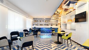 A modern lounge area with seating, a central table, and a patterned floor. - La Meridiana (Sorrento)