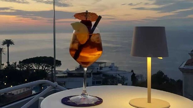 A table with a drink and a lamp, overlooking a scenic view. - La Meridiana (Sorrento)