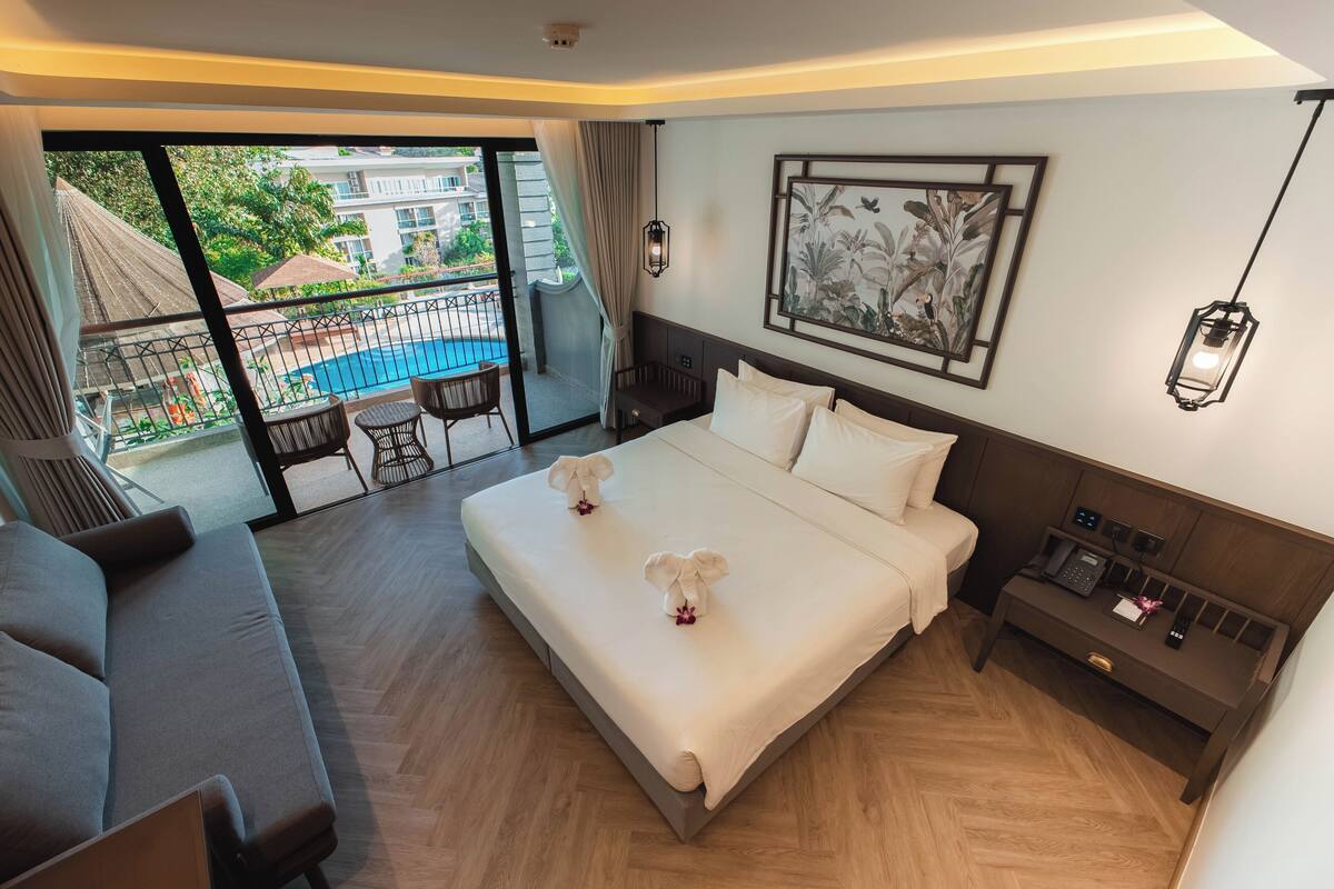 Junior Suite with Pool View | Senger med overmadrass, minibar, safe på rommet og skrivebord