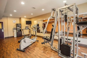 A gym with treadmills, elliptical machines, and weightlifting equipment.
