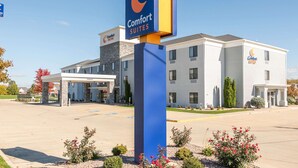 A Comfort Suites hotel with a prominent sign, a parking lot, and a building facade with multiple windows.