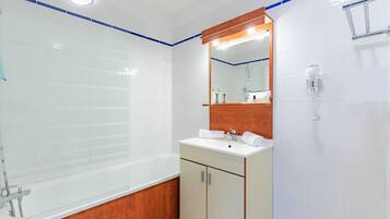 A modern bathroom with a bathtub, a vanity with a mirror, and a towel rack.