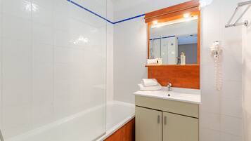 Standaard kamer | Badkamer | Een bad, designer toiletartikelen, een haardroger, handdoeken