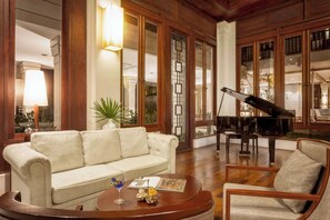 Relax in style with a plush sofa, round coffee table, and grand piano in this elegant living area.
