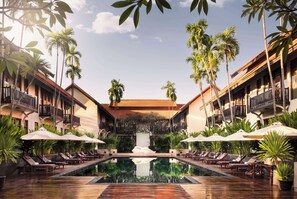 Relax by the pool surrounded by palm trees and a waterfall.